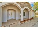 Inviting front entrance featuring an arched stone facade and a well-kept tiled entryway at 18308 Felspar Way, Tampa, FL 33647
