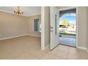 View of a bright, neutral-toned living room with tiled floors leading to the front entrance at 18308 Felspar Way, Tampa, FL 33647