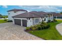 Home features a three car garage and beautifully landscaped grounds at 323 Hawk Talon Dr, Lithia, FL 33547