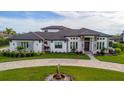 Elegant home features a stone facade, paved driveway, and lush landscaping at 323 Hawk Talon Dr, Lithia, FL 33547