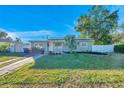 Tan house with solar panels, landscaped yard, and driveway at 7100 14Th N St, St Petersburg, FL 33702