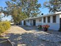Single-story home featuring a long brick driveway leading up to a charming home with unique windows at 2746 Hibiscus St, Sarasota, FL 34239