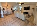 Open living space with light flooring, a white sofa, and a large TV at 3087 Seth Rd, North Port, FL 34288