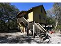 Elevated home with wooden stairs and deck, situated in a wooded area at 39716 Tworut Rd, Webster, FL 33597