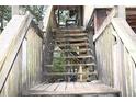 Exterior wooden staircase leading to the elevated home's deck at 39716 Tworut Rd, Webster, FL 33597