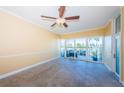 Bright living room with tiled floors, ceiling fan, and sliding glass doors leading to outdoor space at 7400 Sun Island S Dr # 104, South Pasadena, FL 33707