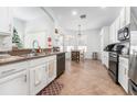 Modern kitchen featuring white cabinets, dark countertops, and stainless steel appliances at 8601 Sandy Plains Dr, Riverview, FL 33578