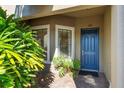 Condo entry with blue door, lush greenery, and brick walkway at 12610 Sorrento Way # 102, Bradenton, FL 34211