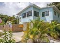 Charming light blue house with a yellow door, and palm trees at 4801 14Th S Ave, St Petersburg, FL 33711
