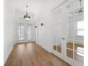 Hallway features hardwood floors, natural light, with glass doors leading to another room at 34 Concord Dr, Dunedin, FL 34698