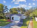 Single story home with a two-car garage and tree-lined street at 918 Windward Way, Palm Harbor, FL 34685
