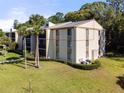 Exterior view of condo building with palm trees at 3101 Lake Pine Way # H3, Tarpon Springs, FL 34688