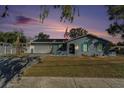 Attractive ranch home with gray exterior, teal accents, and American flag at sunset at 3515 King Richard Ct, Seffner, FL 33584