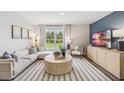 Living room with light sofa, round coffee table, and a large window at 10121 Brushy Creek Pl, Parrish, FL 34219