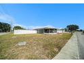 Ranch style home with a large grassy yard, screened patio and a white vinyl fence at 3247 Hoover Dr, Holiday, FL 34691