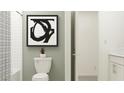 Bathroom with white subway tile, toilet, and framed art at 34717 Kircher Dr, Zephyrhills, FL 33541