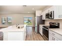 Modern kitchen with white cabinets, stainless steel appliances, and a large island at 7671 Peace Lily Ave, Wesley Chapel, FL 33545