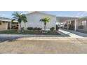 Front view of a single-wide manufactured home with carport and landscaping at 8532 Fantasia Park Way, Riverview, FL 33578