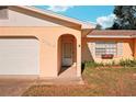 House exterior featuring a light peach color, white garage door, and small front porch at 3044 Golden Rain Dr, Sarasota, FL 34232