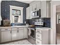 Modern kitchen featuring white shaker cabinets,hexagon tile floors and blue subway tile backsplash at 3508 N Dartmouth Ave, Tampa, FL 33603