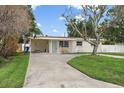 Charming single-story home featuring a well-manicured lawn and a long driveway at 4145 Harrisburg Ne St, St Petersburg, FL 33703