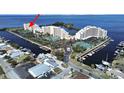 Scenic aerial shot of waterfront condos with tennis courts, lush landscaping, and boat docks at 5915 Sea Ranch Dr # 408, Hudson, FL 34667