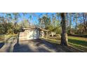 Exterior angle of home shows an attached garage, gated drive and simple architecture at 6906 Quail Hollow Blvd, Wesley Chapel, FL 33544