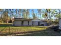 Rear exterior view of the home shows a fenced yard and minimalist backyard at 6906 Quail Hollow Blvd, Wesley Chapel, FL 33544