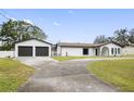 A white house with a black roof and a two-car garage at 16110 N 15Th St, Lutz, FL 33549