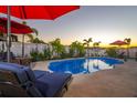 Inviting kidney-shaped pool with lounge chairs and string lights at 13423 White Sapphire Rd, Riverview, FL 33579