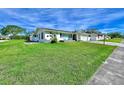 Landscaped yard with a white, single-story home and a long driveway at 14435 Apache Ave, Largo, FL 33774