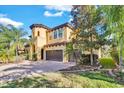 Two-story house with a two-car garage, brick driveway, and lush landscaping at 2847 Calvano Dr, Land O Lakes, FL 34639