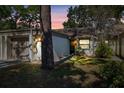 Inviting exterior of a condo with a well-maintained lawn and a one-car garage at 2902 Oak Cir, Tarpon Springs, FL 34689