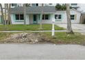 White house with teal shutters and a mailbox; landscaped lawn and palm trees at 59 Acacia St, Clearwater Beach, FL 33767