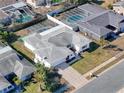 Single-story house with a gray roof, surrounded by other homes and featuring a pool at 8015 Idlebriar Ln, Port Richey, FL 34668