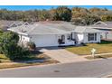 White single-story house with a gray roof, driveway, and well-maintained lawn at 8015 Idlebriar Ln, Port Richey, FL 34668