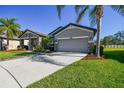 One-story home with stone accents, two-car garage, and palm trees at 8144 Sequester Loop, Land O Lakes, FL 34637