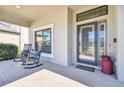 Relaxing front porch with rocking chairs, brick flooring, and entry door at 8144 Sequester Loop, Land O Lakes, FL 34637