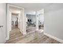 Hallway with wood-look floors and views into living and dining areas at 2062 Sunset Point Rd # 65, Clearwater, FL 33765