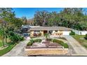 Single-story house featuring a well-manicured lawn and pool at 209 Westwinds Dr, Palm Harbor, FL 34683