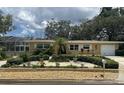 Charming single-story home with well-manicured landscaping, a screened porch and a freshly painted facade at 209 Westwinds Dr, Palm Harbor, FL 34683