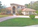 Two story house with circular driveway and lush landscaping at 3050 Wentworth Way, Tarpon Springs, FL 34688