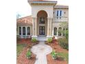 Two-story house with tile roof, arched entry, and landscaped yard at 3050 Wentworth Way, Tarpon Springs, FL 34688