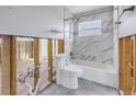 Renovation in progress, showcasing a toilet and bathtub with marble-style tile at 4501 Helena Ne St, St Petersburg, FL 33703