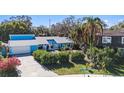 An attractive light blue house with a driveway and lush green landscaping at 7108 Riverwood Blvd, Tampa, FL 33615