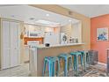 Bright kitchen features white appliances and a breakfast bar with teal stools at 10263 Gandy N Blvd # 202, St Petersburg, FL 33702