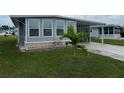 Gray mobile home with covered porch and palm tree at 13225 101St St # 166, Largo, FL 33773