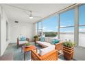 Serene sun room with comfortable seating, ceiling fan, and expansive windows framing a tranquil water view at 1847 Shore S Dr # 509, South Pasadena, FL 33707