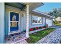 Welcoming front entrance with a blue door, brick walkway, and festive plants at 2175 Nottingham Dr, Clearwater, FL 33764