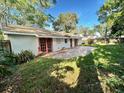 View of the home's back and a large grassy backyard at 621 Hudson Ave, Tampa, FL 33606